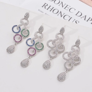 Long tassel drop earrings with colorful cubic zirconia and silver needles on a white table