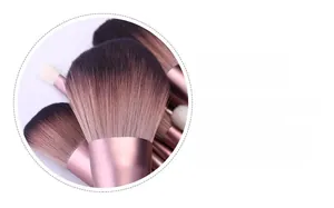 Macro detail of two-tone synthetic bristles and rose gold aluminum tube on a makeup brush