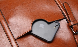 Détail du cabas vintage en cuir marron avec poche extérieure contenant un smartphone