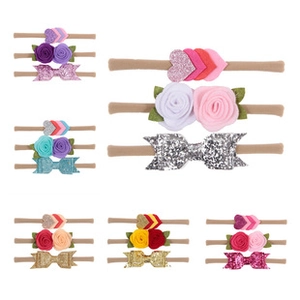 Detailed flat lay of baby nylon headbands with felt flowers and sequin bows in six colors