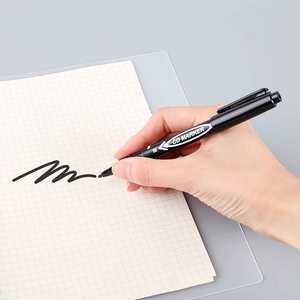 Dual-tip black oil-based marker pen writing fine lines on grid paper