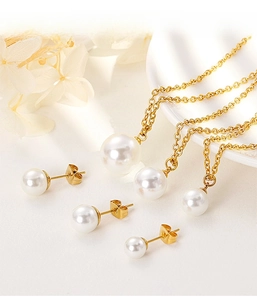 Détail à plat de parures de bijoux en perles dorées avec colliers et boucles d'oreilles
