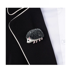 Close-up of a cute hedgehog enamel brooch pinned on a black suit lapel with fashion text