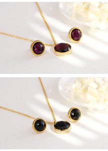 Detail view of gold titanium jewelry set with purple and black round cubic zirconia stones