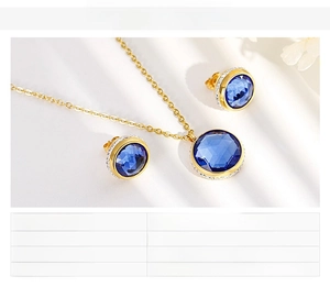 Close-up of gold stainless steel necklace and earrings with blue zircon stones