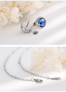 Close-up of stainless steel necklace clasp and blue zircon earrings jewelry set