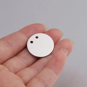 Polished 21mm stainless steel round tag with double holes held by fingers
