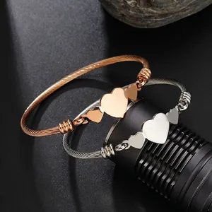 Bracelet câble ouvert en acier inoxydable avec trois cœurs polis en rose et argent
