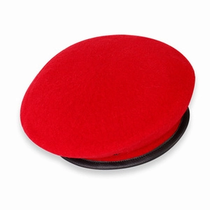 Detail of red wool beret featuring a classic black leather trim edge on white background