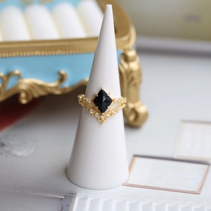 Dettaglio di anelli a corona in argento 925 dorato con opale e pietra arenaria blu su supporto
