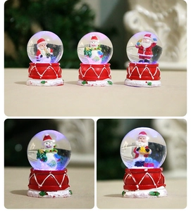 Detail view of glowing Christmas snow globes with Santa Claus and snowman resin figures