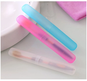 Three translucent pastel portable toothbrush cases in blue, pink, and clear white on a sink