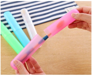 Close-up of hand opening a pink portable travel toothbrush case with multiple colors