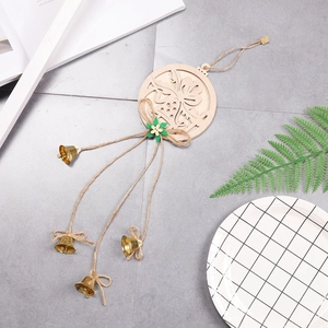 Hollow wooden Christmas tree ornament with green bow and copper bells on grey surface
