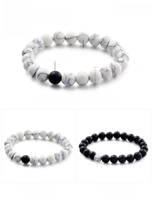 Detail of 8mm matte black agate and white turquoise beaded bracelets with elastic cord