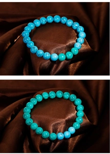 Detailed view of turquoise beaded bracelets in blue and teal on brown satin fabric