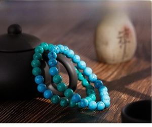 Detailed view of turquoise bead bracelets with natural veining on dark wood