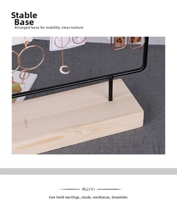 Detailed view of the natural wood base and sturdy black metal frame of the earring stand