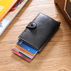 Top view of a black pebbled leather wallet with multiple card slots on a wooden desk