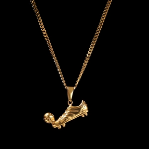 Detailed view of a gold football shoe and ball pendant with high polished metal finish