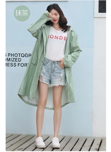 Close-up of lightweight waterproof matcha green raincoat fabric with hood and zipper