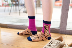 Close-up of pink and orange leopard print cotton socks with dark blue heel and toe detail