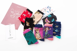 Flat lay of colorful mid-calf cotton socks with diverse animal and butterfly patterns