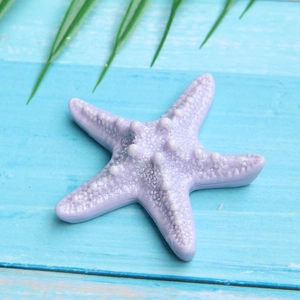 Macro shot of purple resin starfish accessory with realistic texture on blue wood background