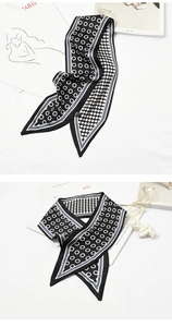 Detail of a narrow silk-like twilly scarf with black and white polka dots and rings