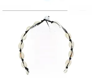 Detail of adjustable Bohemian choker made of white cowrie shells with black braided cord