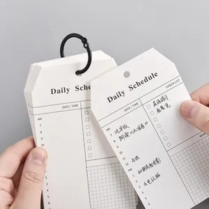 Detail view of white daily schedule planner cards with black metal binder ring
