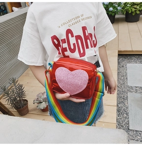 Sac pour enfant rouge métallisé avec cœur pailleté et bandoulière arc-en-ciel en extérieur