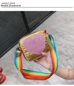 Détail du sac enfant laser doré avec cœur rose pailleté et bandoulière arc-en-ciel