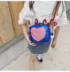 Détail du sac bleu avec cœur en paillettes roses et bandoulière arc-en-ciel