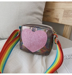 Détail du sac laser holographique avec cœur rose pailleté et bandoulière arc-en-ciel