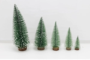 Set of five mini green Christmas trees with snow effect and wooden bases on white background