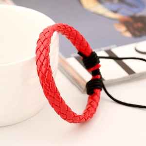 Macro detail of red woven leather bracelet texture leaning against a white cup
