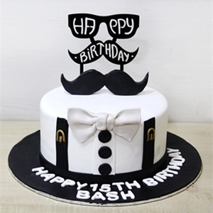 Detail view of tuxedo theme cake topper with black glasses and mustache acrylic sign