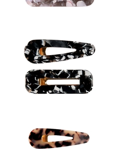 Detail view of acetate hair clips featuring marble, tortoise, and floral patterns