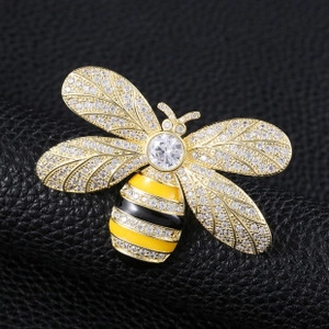 Macro detail of bee brooch with gold finish, sparkling rhinestones and enamel wings