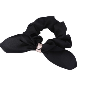 Close-up of black satin hair scrunchie with rabbit ear bow and rose gold metal ring