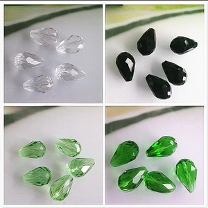 Macro shot of faceted teardrop glass beads in clear, black, apple green, and grass green
