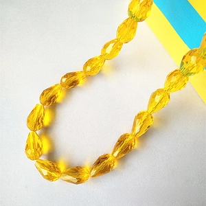 Macro shot of faceted golden yellow teardrop glass beads for DIY jewelry making