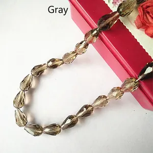 Macro shot of grey faceted teardrop crystal beads on a red display gift box surface