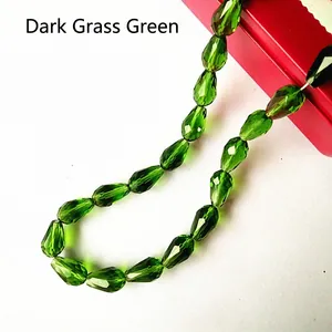 Macro view of faceted deep grass green crystal teardrop beads for jewelry making
