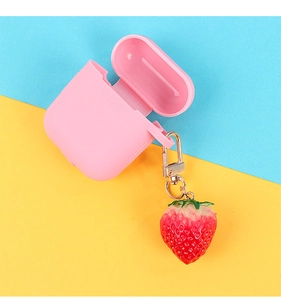 Pink silicone earphone case with realistic strawberry charm on vibrant background