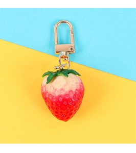 Detail of cute strawberry pendant with golden metal clasp and realistic seed textures