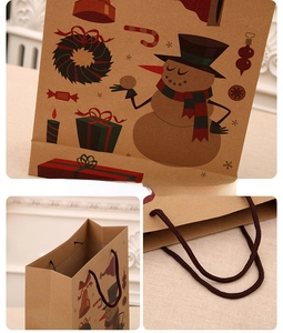 Detail view of Christmas kraft paper gift bag with snowman patterns and sturdy handles