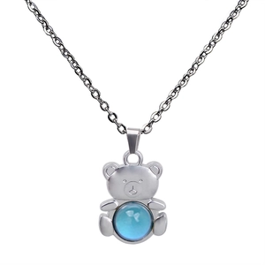 Makroaufnahme eines Teddybären-Anhängers mit blauem Stimmungsstein und Silberkette