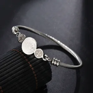 Detail view of Saint Benedict silver stainless steel cable bracelet with three religious medals